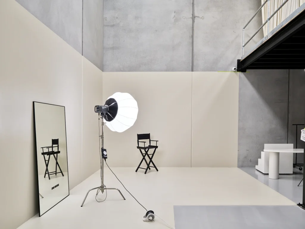 Studio photo épuré avec projecteur, chaise de réalisateur et miroir